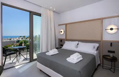 a bedroom with a bed with towels on it at Villa Manu Luxury Living in Stalos