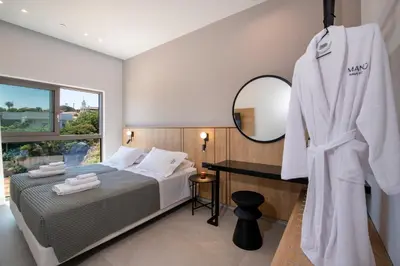 a master bedroom with a bed and a mirror at Villa Manu Luxury Living in Stalos