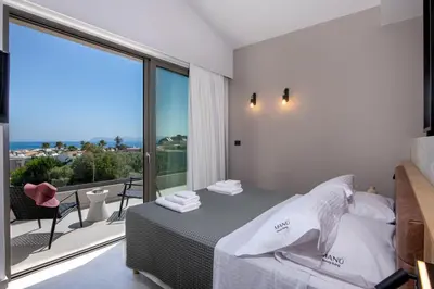 a bedroom with a bed and a large window at Villa Manu Luxury Living in Stalos