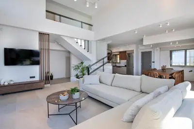 a living room with a white couch and a table at Villa Manu Luxury Living in Stalos