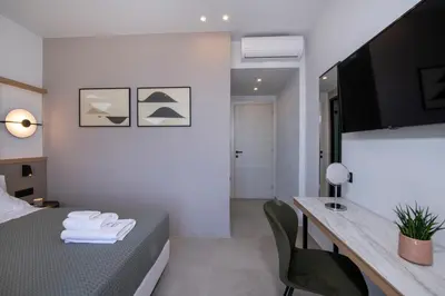 a hotel room with a bed and a desk and chair at Villa Manu Luxury Living in Stalos