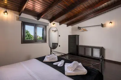 a bedroom with a bed with a mirror and towels at Eightyfour Living with private pool in Chania Town