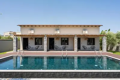 a villa with a swimming pool in front of a house at Eightyfour Living with private pool in Chania Town