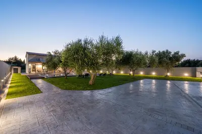 a courtyard with trees in front of a building at Eightyfour Living with private pool in Chania Town