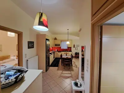 a kitchen and living room with a table and a dining room at Mavrogenis Farm Chania Crete in Plataniás