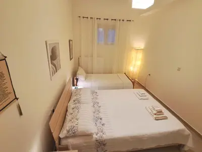 a small bedroom with two beds and a window at Mavrogenis Farm Chania Crete in Plataniás