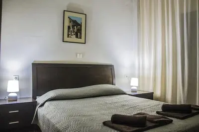 a bedroom with a bed with two lamps and two towels on it at Nelly's House in Chania Town