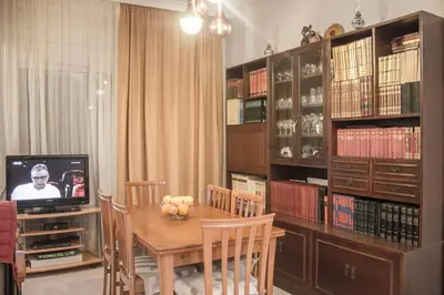 a dining room with a table and a tv in a library at Nelly's House in Chania Town