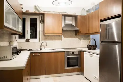 a kitchen with wooden cabinets and a stainless steel refrigerator at Nelly's House in Chania Town