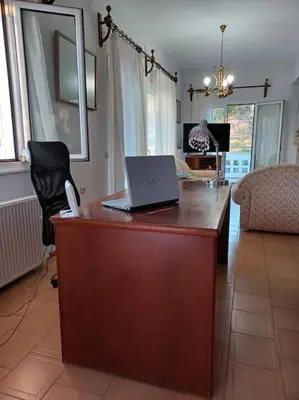 a desk with a laptop on it in a living room at Casa Dastele remarkable seaview 5' from the sea in Chania Town