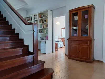 a living room with a staircase and a book shelf at Casa Dastele remarkable seaview 5' from the sea in Chania Town