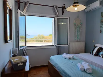 a bedroom with two beds and a large window at Casa Dastele remarkable seaview 5' from the sea in Chania Town