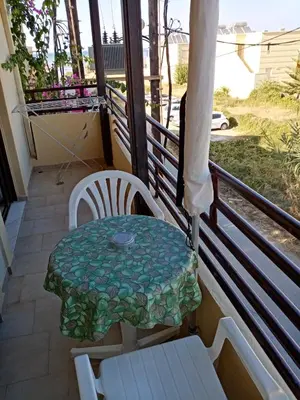a table and chairs sitting on a balcony at John Apartments in Plataniás