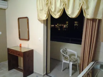 a bathroom with a mirror and a chair and a window at John Apartments in Plataniás
