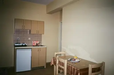 a small kitchen with a table and a table and chairs at John Apartments in Plataniás