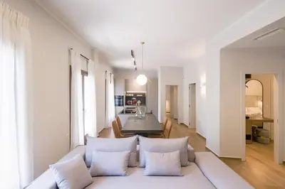 a living room with a white couch with pillows at In Heart of Old Town Saint Rocco's Chic Apt in Chania Town