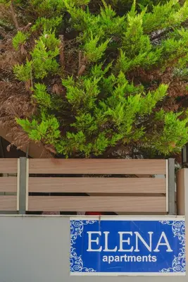 a sign for elena apartments in front of a tree at Elena Apartments in Kato Daratso