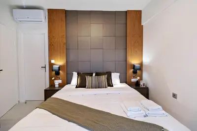 a bedroom with a large bed with two towels on it at Elia Beach Deluxe Apartment in Chania Town