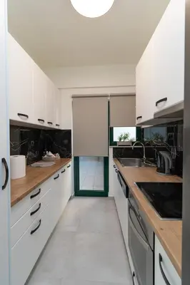 a kitchen with white cabinets and wooden counter tops at Elia Beach Deluxe Apartment in Chania Town