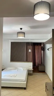 a bedroom with a white bed and two lights at Emerald Suites in Vryses