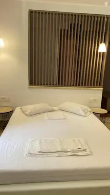 a white bed with a towel on top of it at Emerald Suites in Vryses