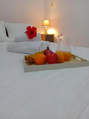 a tray of fruit and a jug of juice on a bed at Casa Artemis in Plátanos