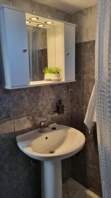 a bathroom with a white sink and a mirror at Casa Artemis in Plátanos