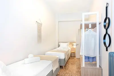 a small room with two beds and a mirror at JasmineStay - Two bedroom apartments with backyard in Chania Town