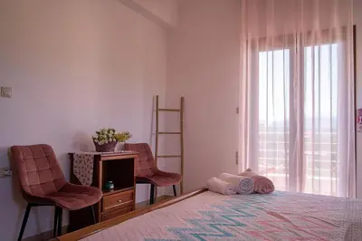 a bedroom with a bed with two chairs and a desk at Al Aker Villa with private pool in Kalathas