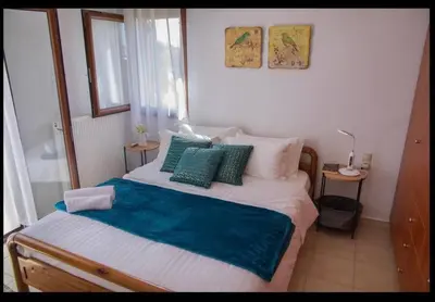 a bedroom with a bed with a blue blanket and pillows at Al Aker Villa with private pool in Kalathas