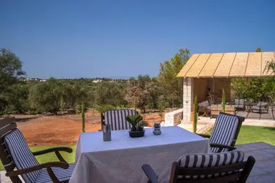 a table with a blue table cloth and four chairs at Al Aker Villa with private pool in Kalathas