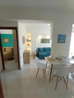 a living room with a table and a blue couch at Ethereum City Αpartment - Suite in Chania Town