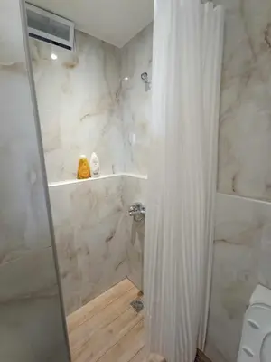 a shower with a shower curtain in a bathroom at Ethereum City Αpartment - Suite in Chania Town