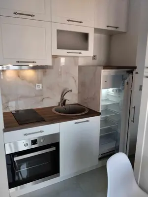 a kitchen with white cabinets and a sink and an oven at Ethereum City Αpartment - Suite in Chania Town