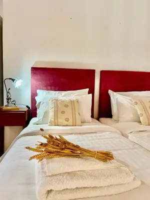 a white bed with a red headboard and some pillows at Erietta Suites in Chania Town