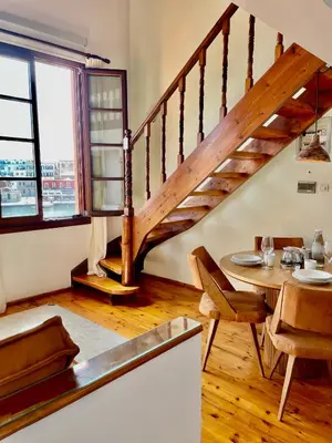 a dining room with a table and a staircase at Erietta Suites in Chania Town