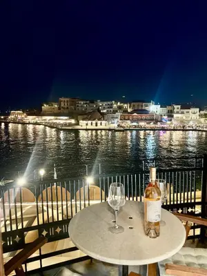 a table with a bottle of wine and a glass at Erietta Suites in Chania Town