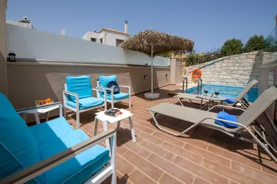 a patio with chairs and a swimming pool at Villa Constancia in Stalos