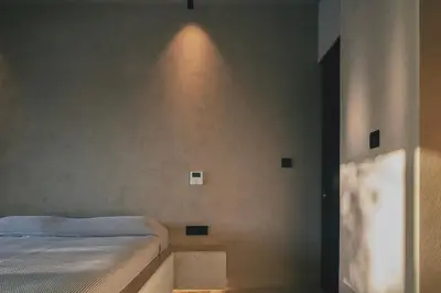 a bedroom with a bed with a light on the wall at Inspiration House in Souda