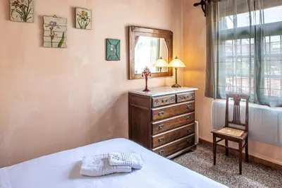 a bedroom with a bed and a dresser and a mirror at Thimari Gardens in Chania Town