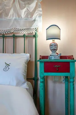 a lamp on a table next to a bed at Thimari Gardens in Chania Town