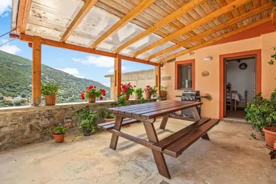 a wooden picnic table on a patio with a view at Maria's House with View in Kambos in Kámbos