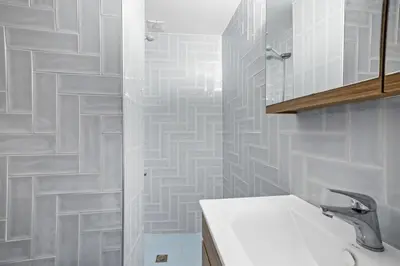 a white bathroom with a sink and a shower at Maria's House with View in Kambos in Kámbos