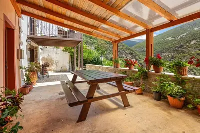 a wooden picnic table on a patio with a view at Maria's House with View in Kambos in Kámbos