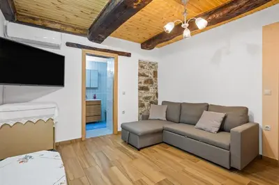 a living room with a couch and a flat screen tv at Maria's House with View in Kambos in Kámbos