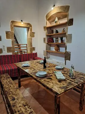 a wooden table in a living room with a red couch at Villa Nama in Kissamos