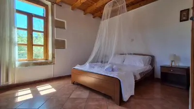 a bedroom with a bed with a mosquito net at Villa Nama in Kissamos