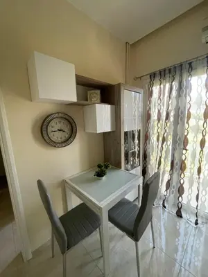 a dining room with a table and chairs and a clock at Anastasia City Home in Chania Town