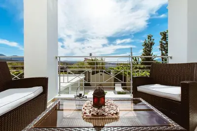 a patio with two chairs and a table on a balcony at Suite Erato in Kissamos