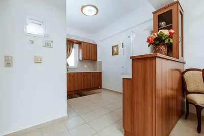 a living room with a vase of flowers on a cabinet at Suite Erato in Kissamos